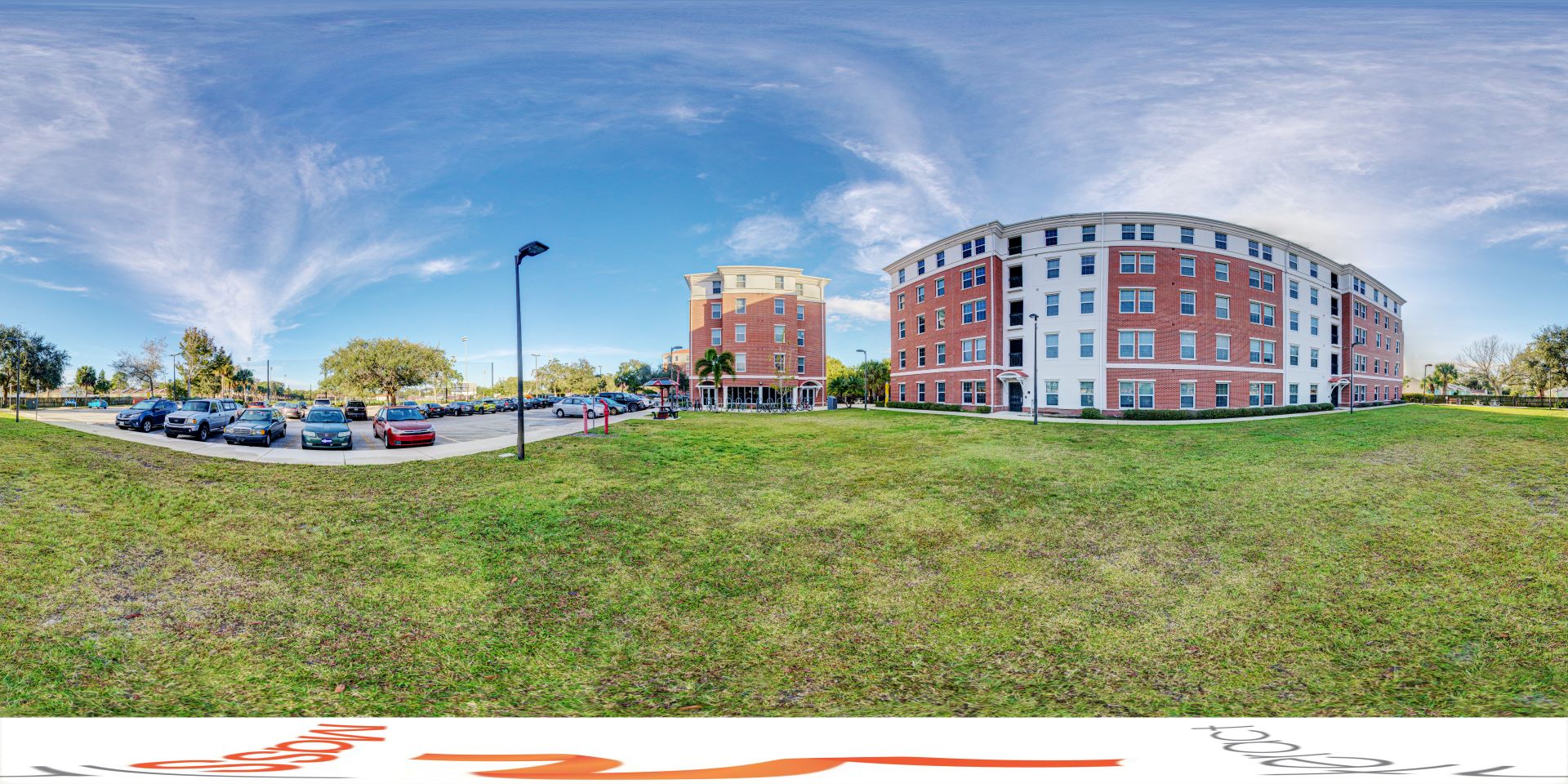 Panoramic view of the building from the grassy area next to the large parking lot